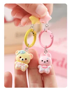 Cute cartoon bear and bunny keychain pendant detail, pastel color charm accessory.