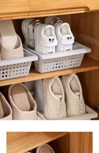 Detail shot of white plastic shoe storage box featuring breathable holes inside wooden cabinet.