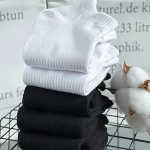 Detail view of stacked black and white cotton short socks, comfortable and breathable everyday wear.