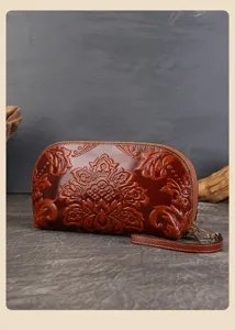 Vue détaillée de la pochette en cuir ciré gaufré vintage, motif floral élégant, dragonne.