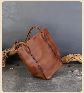 Vista dettagliata della borsa tote in pelle marrone retro con doppi manici in scena rustica.