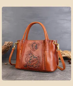 Handgemaakte in relief gedrukte lederen tas met ingewikkeld bloemmotief en vintage bruine afwerking.