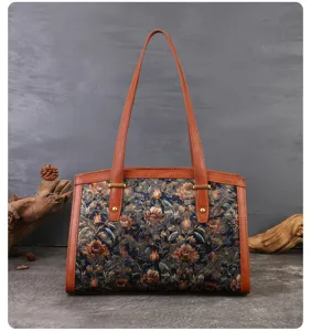 Detailed shot of vintage floral embroidered shoulder bag with brown leather trim.