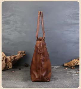 Side view detail of vintage genuine leather tote bag showing spacious capacity and fine stitching.