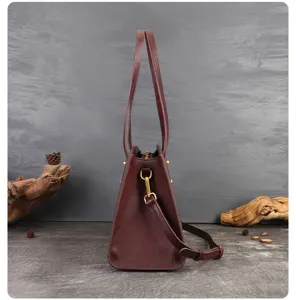 Detailed view of dark brown leather shoulder bag, highlighting durable side profile and hardware.