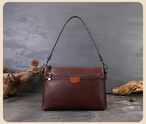 Detailed view of the dark brown leather shoulder bag featuring multi-layer zip compartments.