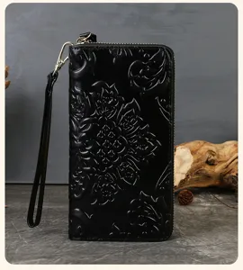 Black genuine leather women wallet with embossed floral design and wrist strap detail.