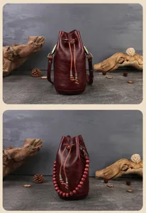 Detailed shot of retro maroon leather bucket bag, drawstring design with rustic props.