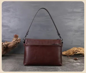 Detailed view of the brown leather shoulder bag showing multi-layer design and hardware.