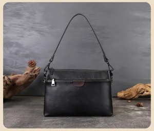 Close-up view of the black multi-layer leather shoulder bag, highlighting texture and detail.
