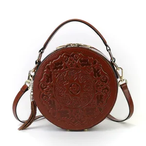 Vintage embossed round leather handbag with top handle shoulder strap and tassel charm main view