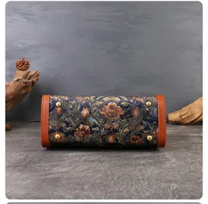 Detailed view of the vintage embroidered handbag bottom with leather trim and metal feet.