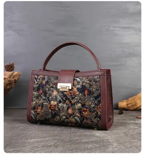 Vintage floral embroidered top handle bag with brown leather trim and secure metal lock clasp.