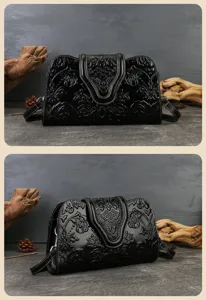 Black embossed leather evening bag detail, retro style floral pattern underarm clutch purse.