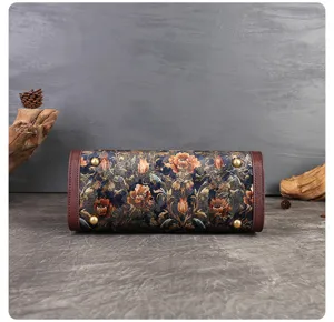 Detailed bottom view of vintage embroidered handbag with floral pattern and protective metal feet.