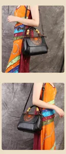 Detail view of black vintage embossed leather crossbody bag with unique bamboo top handle design.