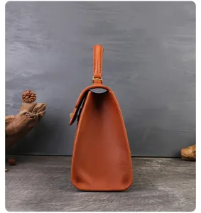 Vintage brown leather top handle bag with classic trapezoid silhouette and elegant design for women