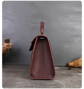 Side detail view of luxury leather handbag, elegant maroon design with premium texture craftsmanship.