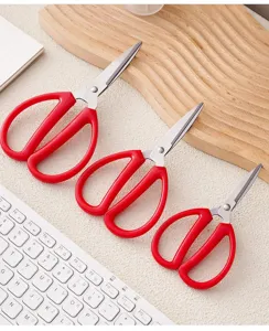 Set of three red handle household office scissors stainless steel blades detail view