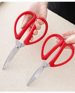Stainless steel household scissors, red handle manual paper cutting tool detail view.
