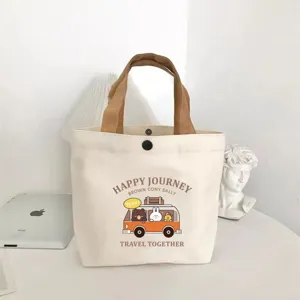 Cute cartoon canvas tote bag detailed view, small lunch handbag with brown handles and prints.