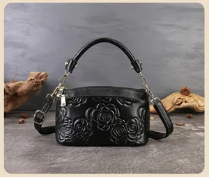 Borsa a tracolla in pelle nera goffrata con manico superiore e dettagli metallici eleganti.