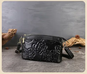 Borsa a tracolla in pelle nera con motivo floreale impresso, design elegante e chic.