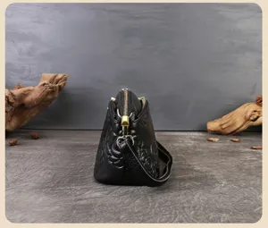 Vista dettagliata della borsa da donna in vera pelle nera con profilo laterale.