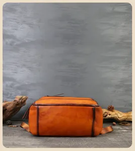 Handmade vegetable-tanned leather backpack bottom detail, vintage brown cowhide texture.