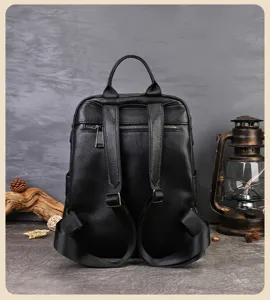 Vue détaillée du sac à dos en cuir noir montrant les bretelles, fermetures et texture fine.
