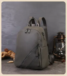 Vue détaillée du sac à dos en cuir gris avec fermoirs diagonaux et belle lanterne vintage.