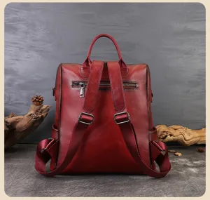 Detail shot of vintage red leather backpack showing rear zipper pocket and adjustable straps.