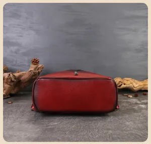 Detailed view of the wine red leather backpack bottom showcasing gradient finish and fine texture.