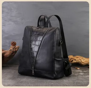 Detail view of stylish black women leather backpack with crocodile texture panel and zippers.