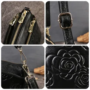 Borsa a tracolla da donna in vera pelle nera con elegante design floreale in rilievo e tracolla.