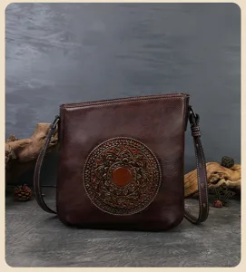 Vintage embossed leather shoulder bag with intricate circular totem detail, stylish and versatile.