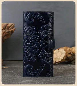 Vue détaillée d'un long portefeuille en cuir bleu foncé avec motif gaufré vintage.