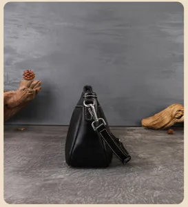 Detail view of retro black cowhide shoulder bag, showing side profile, hardware and fine stitching.