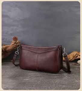 Close-up view of the vintage brown genuine leather baguette bag showing fine stitching details.