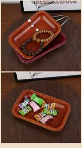 Gros plan d'un plateau vide-poches en cuir rétro avec coutures contrastées pour le bureau.