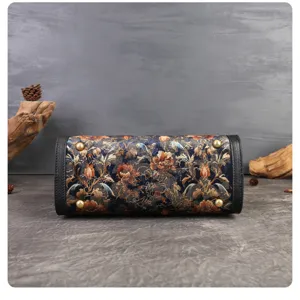 Vintage embroidered handbag bottom detail showing floral tapestry design and metal feet.