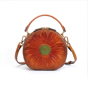 Retro genuine leather round handbag with embossed sunflower design, top handle and strap.