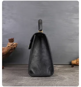 Black leather handbag side view detail, elegant retro style commuting shoulder bag design.