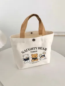 Detailed view of the cute cartoon bear canvas tote bag with contrast brown handles and snap closure.