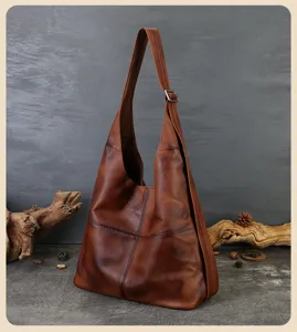 Genuine leather hobo bag detail shot, featuring vintage cowhide texture and adjustable wide strap.