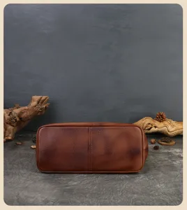 Detail shot of the brown genuine leather tote bag bottom, showcasing fine retro texture.