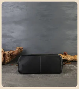 Black genuine leather tote bag bottom detail view, premium vintage cowhide craftsmanship.