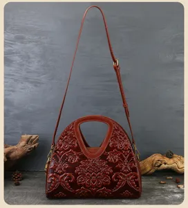 Detailed view of vintage embossed leather handbag showing intricate floral pattern and hardware.
