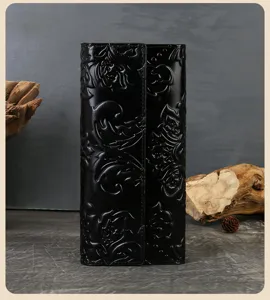 Detailed shot of premium black genuine leather trifold wallet with vintage embossed floral design.