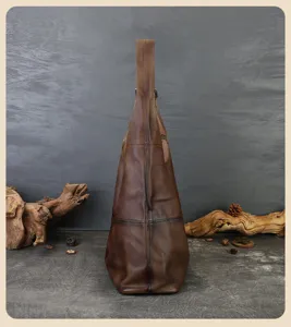 Side profile detail view of vintage brown genuine leather tote shoulder bag with wide strap.